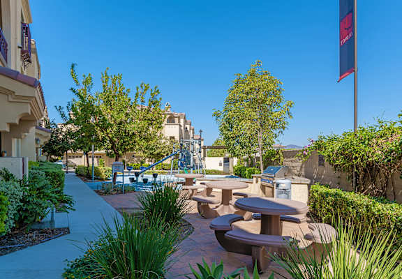 A park with tables and chairs and a flag.