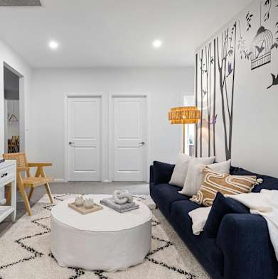 a living room with a blue couch and a white coffee table