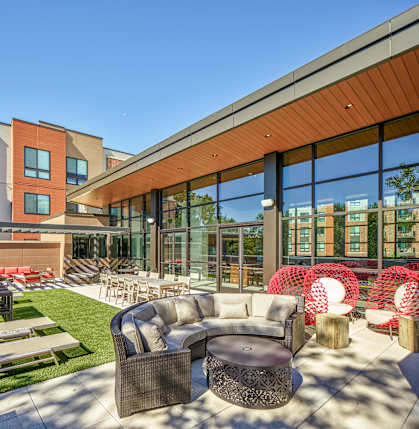 A modern outdoor seating area with a variety of chairs and tables.