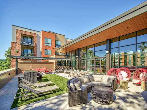A modern outdoor seating area with a variety of chairs and tables.