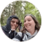 Two people wearing winter jackets are standing outside.