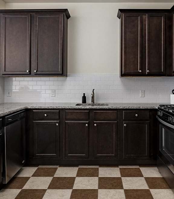 A kitchen with black cabinets and a checkered floor.