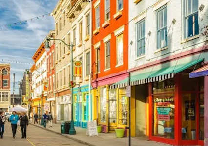 A street scene with people walking and colorful buildings.