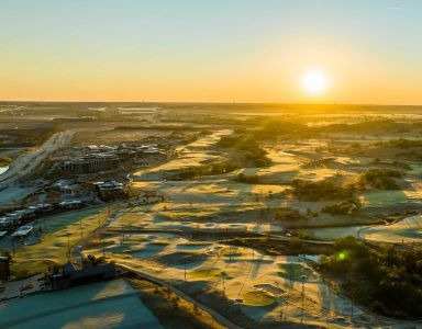 A sunset view of a landscape with a mix of water bodies and greenery at Civic at Frisco Square Apartments, Frisco, TX, Texas