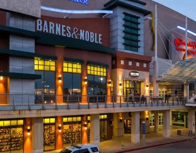 A Barnes & Noble bookstore is shown at dusk with lights on inside at Civic at Frisco Square Apartments, Texas, 75034