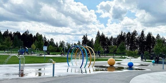 A playground with a water feature and a slide. at Madison Sierra Sun, Puyallup, 98374