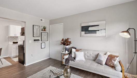 a living room with a couch a table and a lamp
