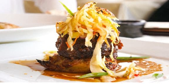 A dish with meat and sauce on a white plate. at Madison Sierra Sun, Puyallup, 98374
