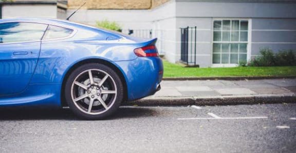 a blue car parked on the side of a street