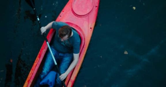 a man is in a red kayak in the water