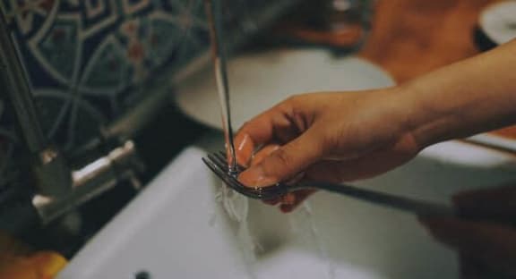 a person washing their hands in a sink