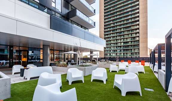 a group of white chairs on a lawn in front of a building