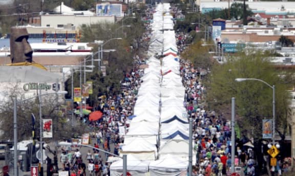 a view from above of a long line of tents on a city street