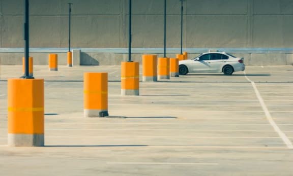 a white car is parked in a parking lot