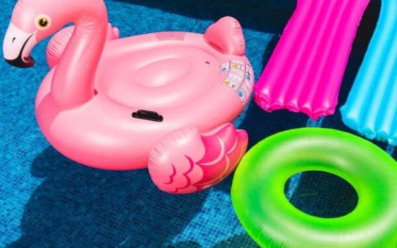 a pink inflatable flamingo toy on a blue
