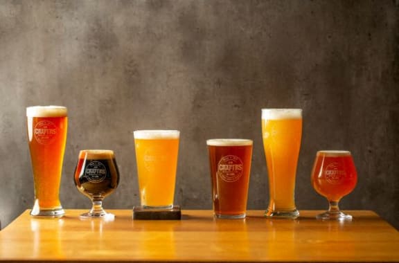 a row of beer glasses on a wooden table