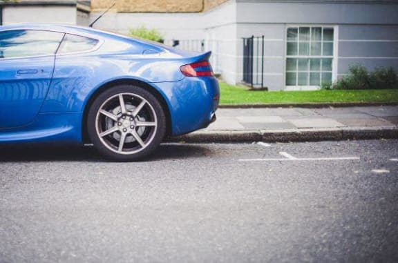 a blue car parked on the side of a street