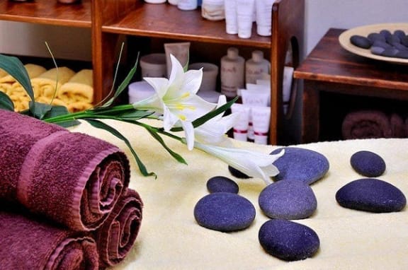 a towel sitting on a table with rocks and a flower