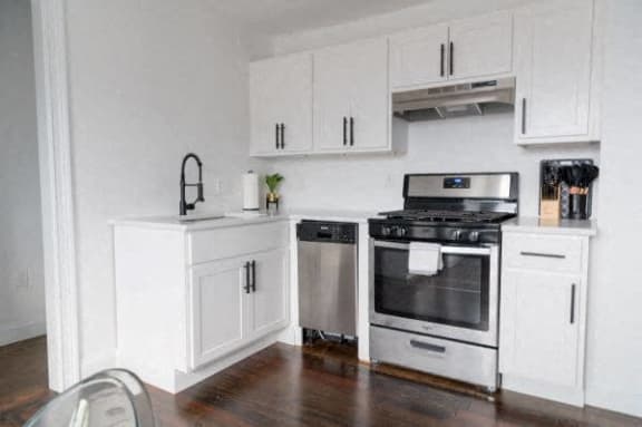 a white kitchen with stainless steel appliances and white cabinets