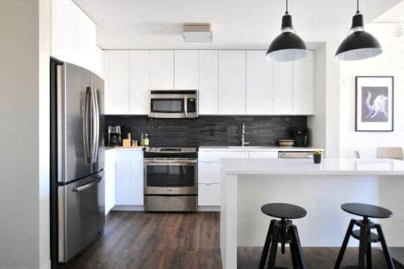 a kitchen with a bar and stools and a refrigerator