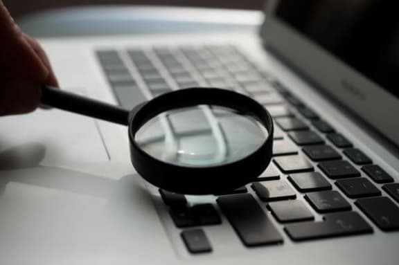 a magnifying glass sitting on top of a laptop