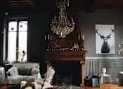 Thumbnail 1 of 4 - a living room with a fireplace and a chandelier