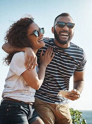 a man and a woman standing next to a car