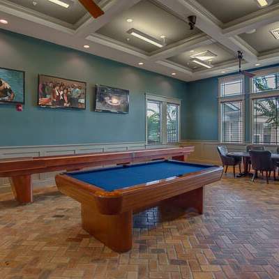 A room with a pool table and a bar.