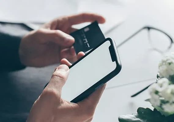 A person holding a smartphone with a white screen.
