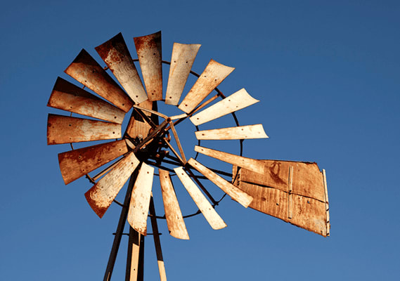 A windmill with a blue sky in the background.