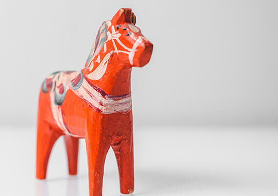 a red and white horse figurine on a white surface