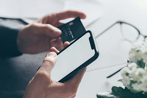 A person holding a smartphone with a white screen.