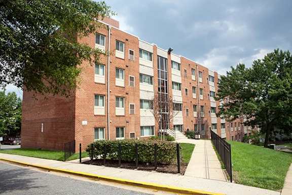 a brick apartment building on the side of a sidewalk