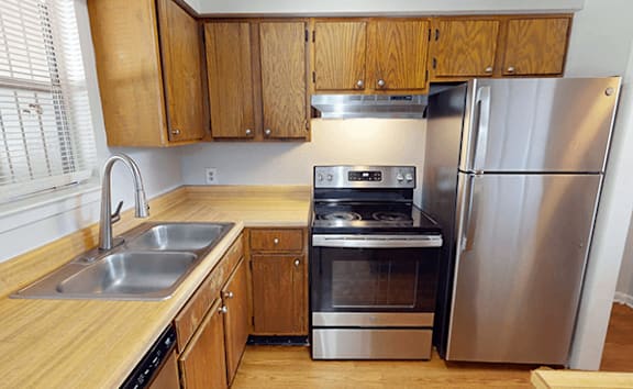 A kitchen with wooden cabinets and stainless steel appliances.