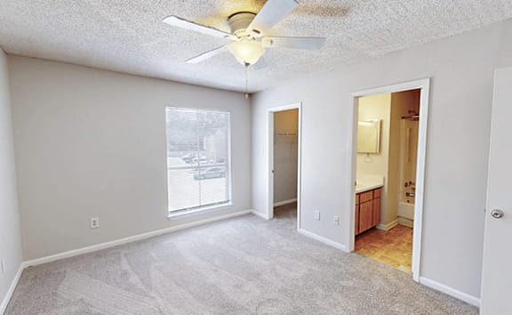 A room with a ceiling fan and a carpeted floor.