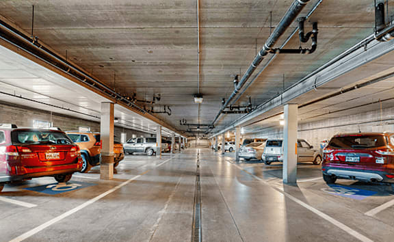 A parking garage with cars parked on both sides.