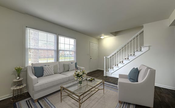 a living room with a white couch and a staircase