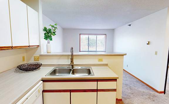 A kitchen with white cabinets and a red stripe on the counter.