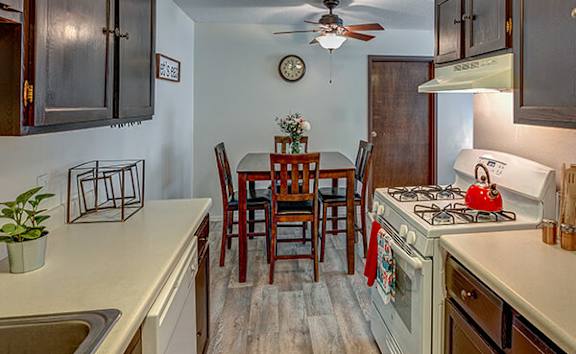 A kitchen with a table and chairs.