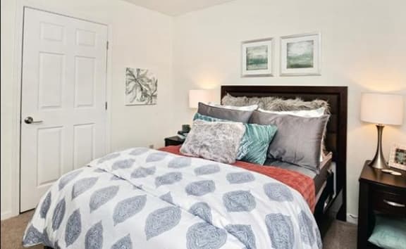 a bedroom with a bed and two lamps