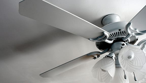 A white ceiling fan with five blades and a light fixture.