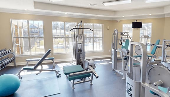 a gym with various exercise equipment and windows