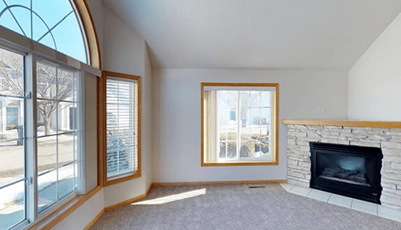 A living room with a fireplace and a large window.