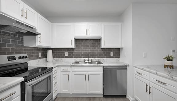 A kitchen with white cabinets and a black stove top oven.