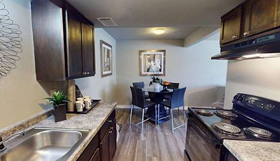 A kitchen with dark wood cabinets and a black stove top oven.