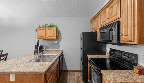 a kitchen with black appliances and granite counter tops