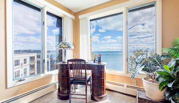 a home office with a desk and a view of the ocean