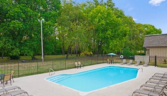 a swimming pool with chairs and chairs around it