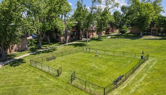 a fenced in soccer field in the middle of a park