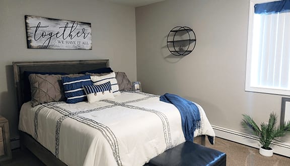 A bedroom with a bed, a bench, and a sign that says "together we have it all".